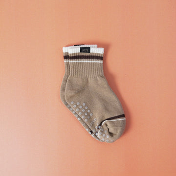 Beige ankle sock with grip dots on a peach background
