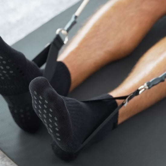 Person wearing black textured socks on a yoga mat