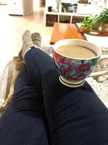 Person sitting with a colorful mug of coffee on a casual setting