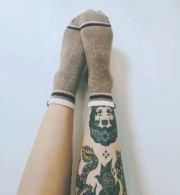 Beige socks with black stripes worn by a person on a white background