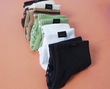 Set of colorful socks with a brand label on a peach background
